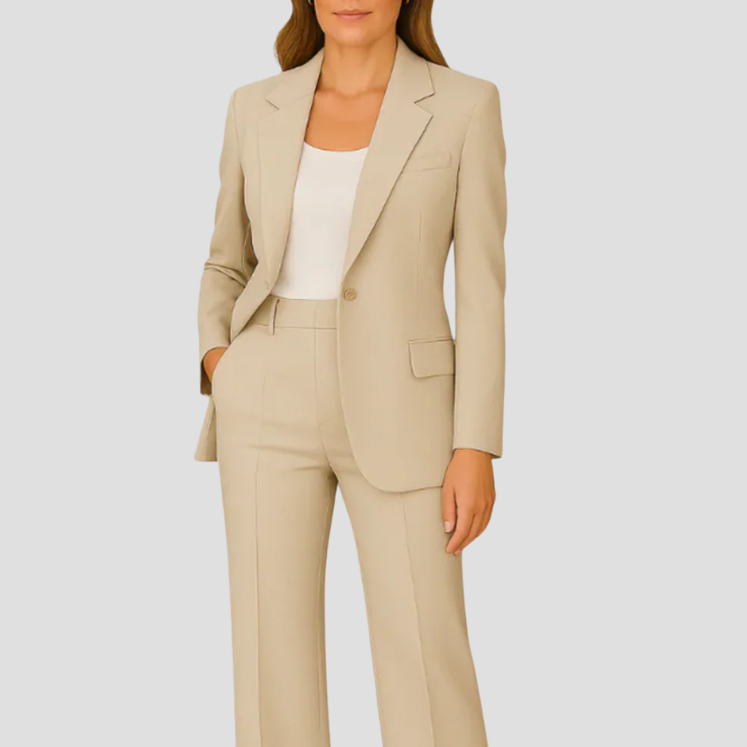 Modell i beige kavaj och matchande byxor med vit topp under och hand i fickan 7