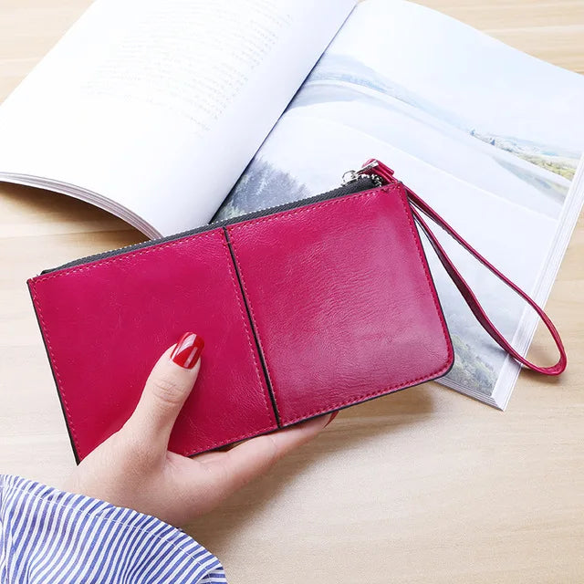 Rote Lederhandtasche mit Reißverschluss, Damenmode, elegantes Design, auf Holztisch.