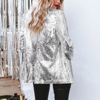 Frau in silbernem Paillettenblazer, blonde Haare, schwarze Lederhose, festliche Mode.