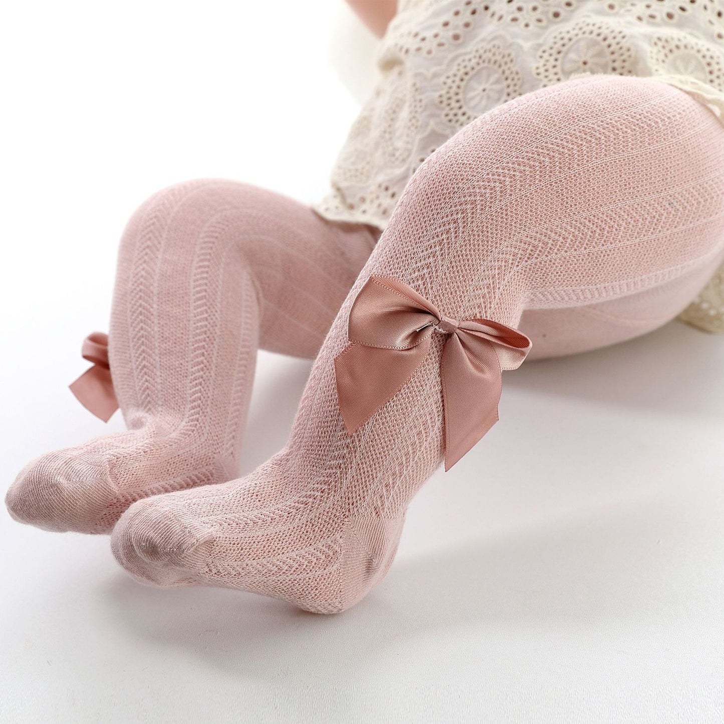 Rosa Babystrumpfhose mit Schleifen, Spitzenmuster, Baumwolle, für Mädchen, elegant und bequem.