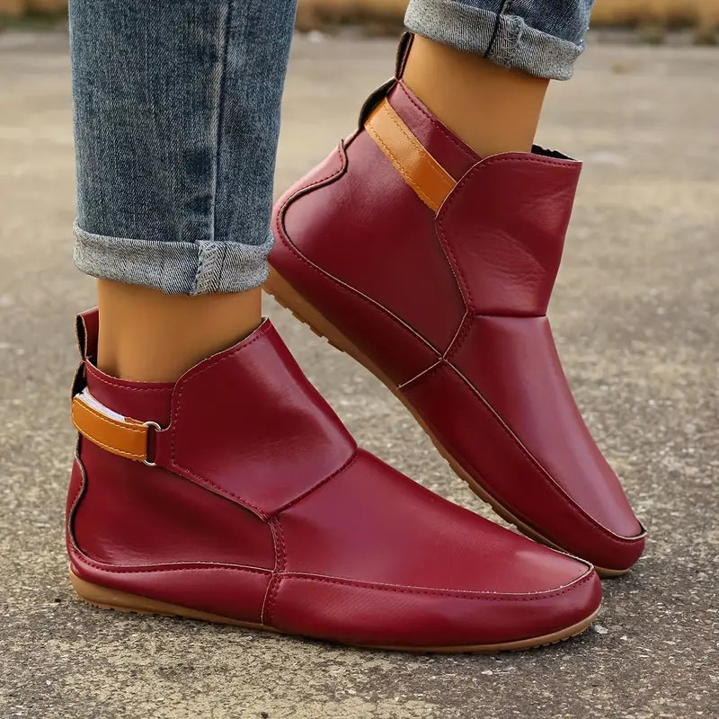 Rote Damenstiefeletten aus Leder, flach, mit braunem Riemen, modisch, bequem.