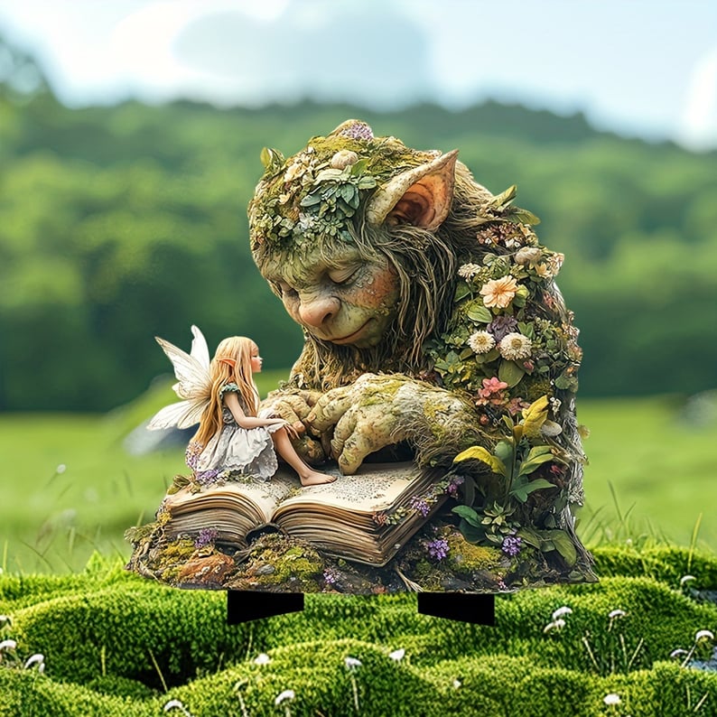 Mossgrön trollfigur som läser i en uppslagen bok med en liten älva på sidan, stående på mossa utomhus. 2