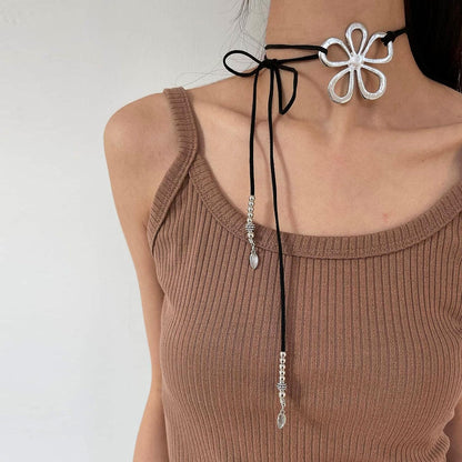 Frau mit schwarzem Halsband, silberne Blume, modisches Accessoire, elegantes Design.