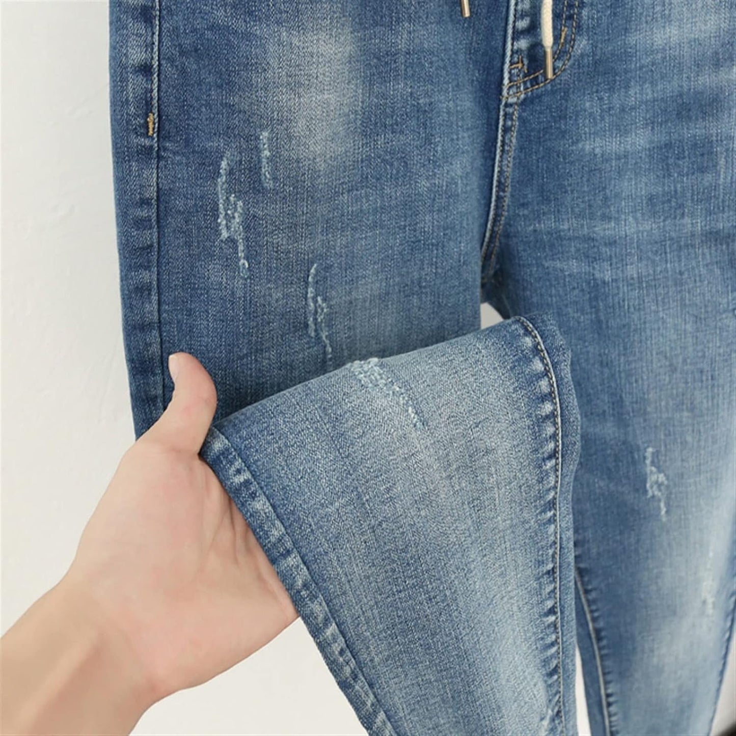 Blaue Jeans mit Used-Look, handgehalten, Denim, modisch, lässig, Detailansicht.