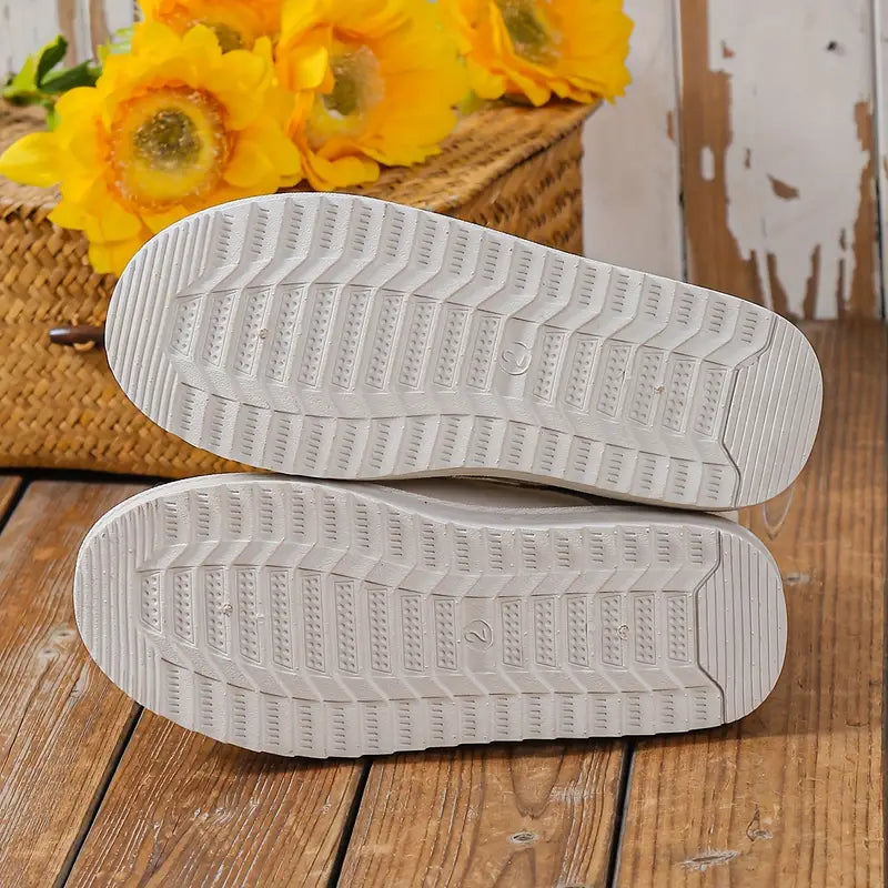 Weiße Sneaker-Sohlen auf Holzboden, gelbe Sonnenblumen im Hintergrund, Korbdekor.