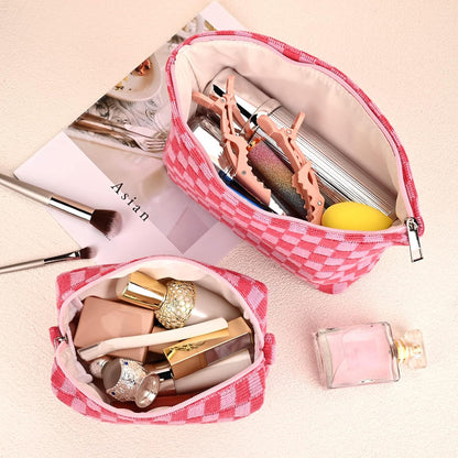 Rosa karierte Kosmetiktasche, gefüllt mit Make-up, auf hellem Hintergrund.