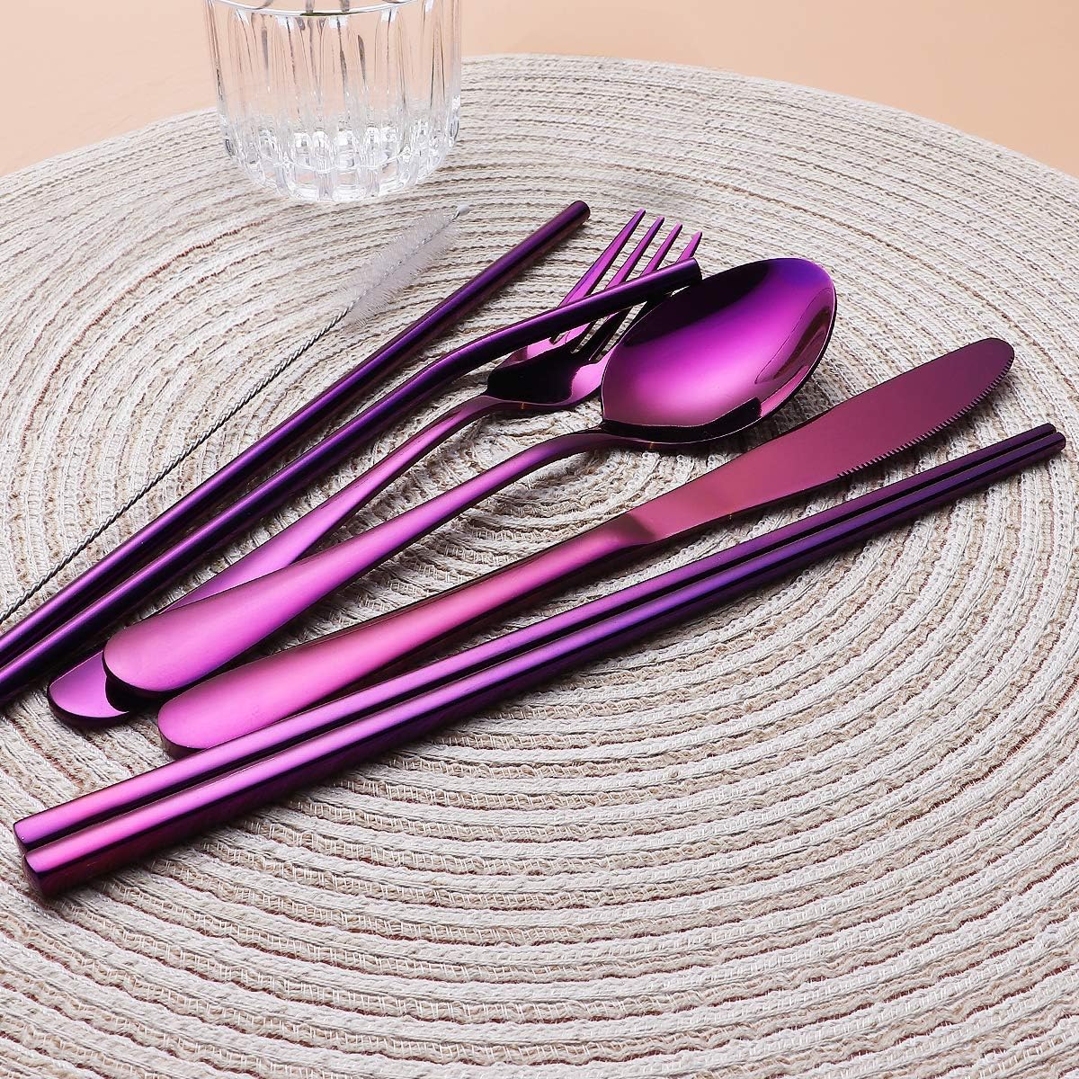 Lila Edelstahl-Besteckset auf rundem Platzdeckchen, modernes Design, Essbesteck.