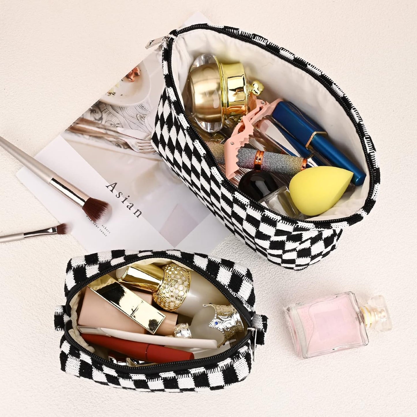 Schwarz-weiß karierte Kosmetiktasche mit Make-up, Lippenstift, Pinsel und Parfümflasche.