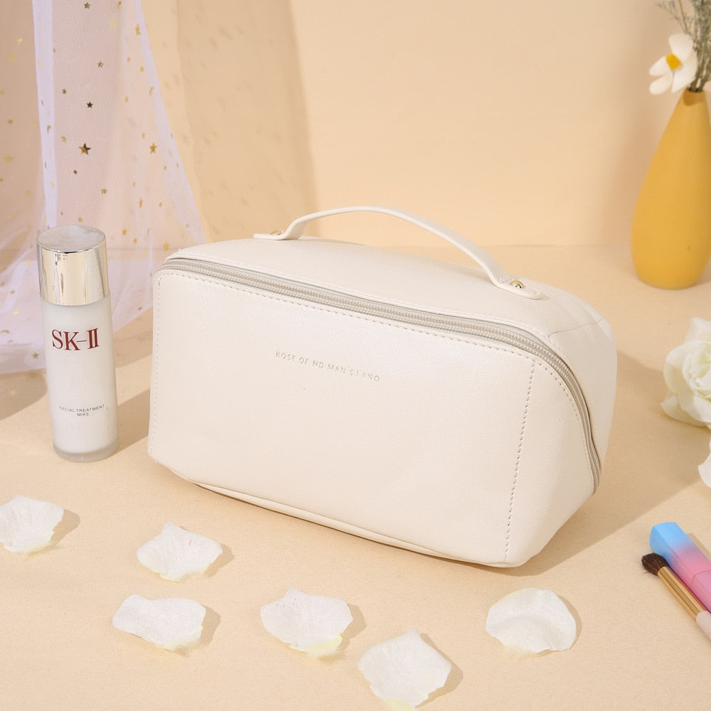 Weiße Kosmetiktasche aus Leder mit Reißverschluss, ideal für Reisen und Make-up-Aufbewahrung.