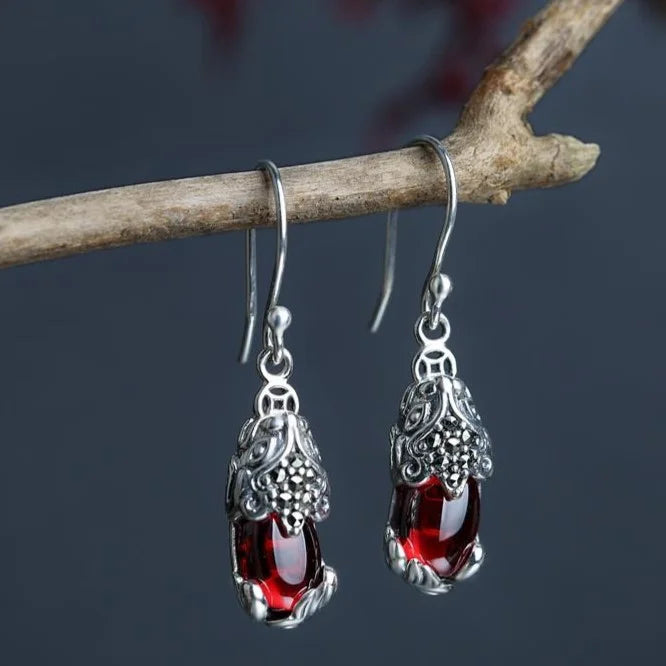 Silberne Ohrringe mit roten Edelsteinen, filigranes Design, Schmuck für Damen, elegant und stilvoll.