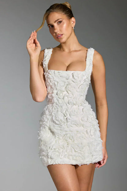 Frau in weißem, ärmellosem Blumenkleid, elegantes Design, Modefotografie.