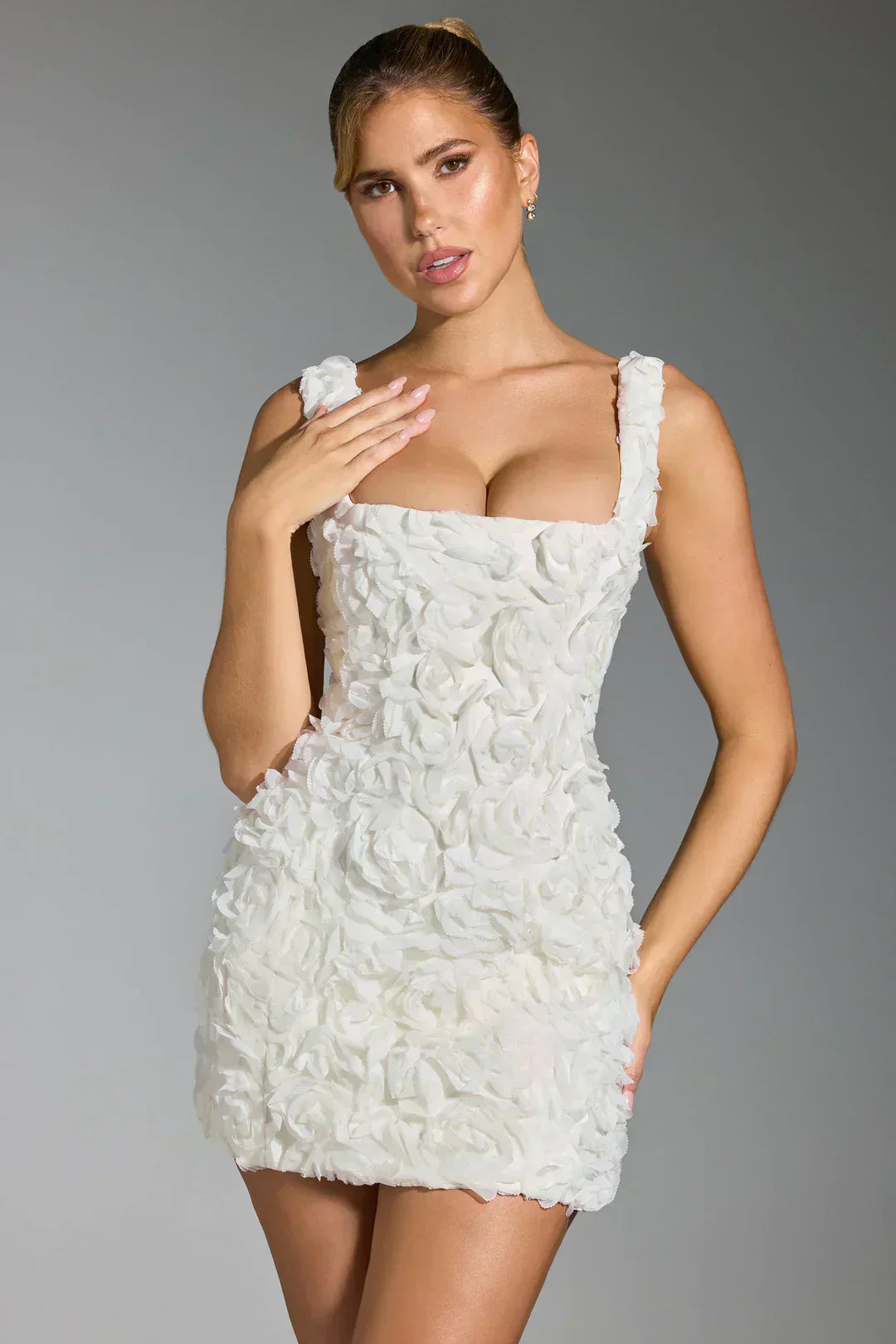 Frau in weißem Blumenkleid, ärmellos, figurbetont, elegantes Design, Modefotografie.
