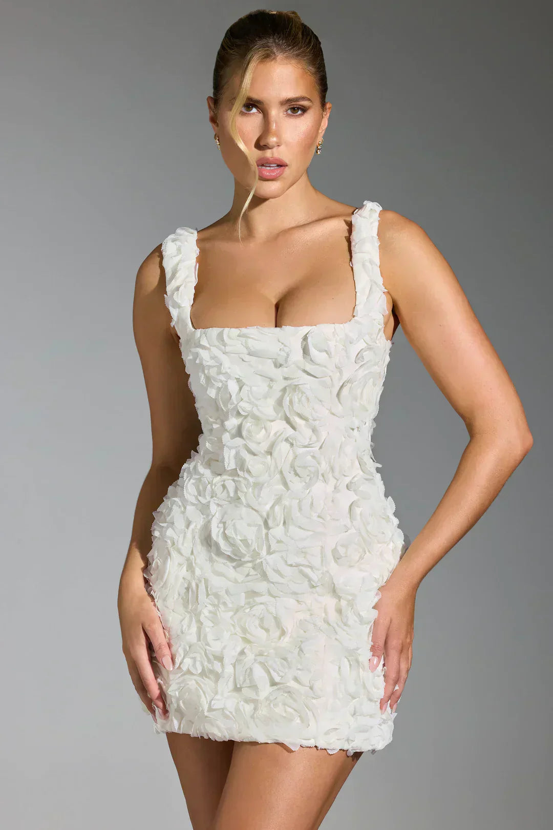 Weißes Minikleid mit Rosenmuster, ärmellos, elegantes Design, ideal für besondere Anlässe.