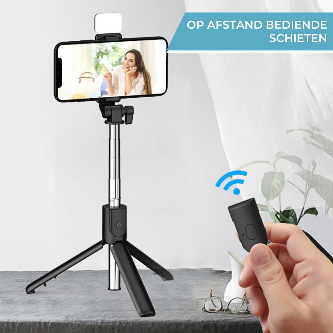 Schwarzes Selfie-Stativ mit Smartphone-Halterung und Fernbedienung auf Tisch, ideal für Fotografie.