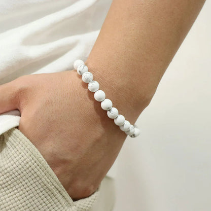 Weiße Howlith-Armband, elastisch, unisex, auf Handgelenk getragen, modisches Accessoire.