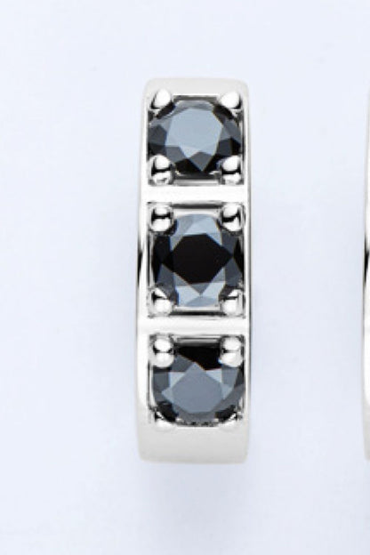 Silberner Ring mit drei schwarzen Diamanten, elegantes Schmuckdesign, luxuriöses Accessoire.