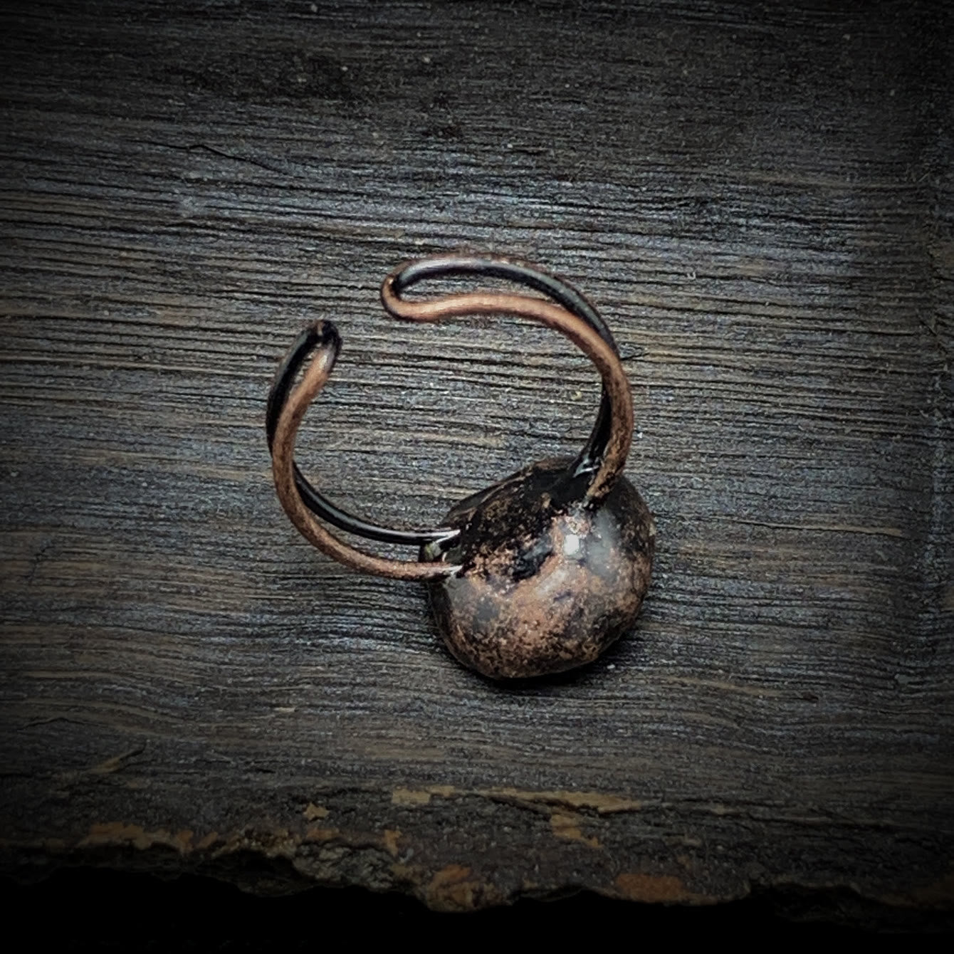 Rustikaler, handgefertigter Kupferring auf Holzoberfläche, Vintage-Schmuck, Unikat.
