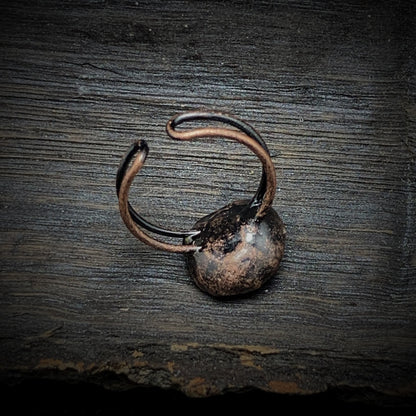 Rustikaler, handgefertigter Kupferring auf Holzoberfläche, Vintage-Schmuck, Unikat.
