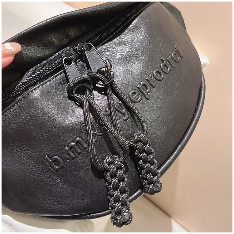 Schwarze Leder-Bauchtasche mit Reißverschluss und geprägtem Logo, modisch und praktisch.