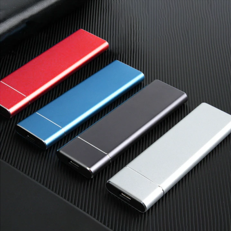 Vier USB-Sticks in Rot, Blau, Schwarz und Silber auf schwarzem Hintergrund.