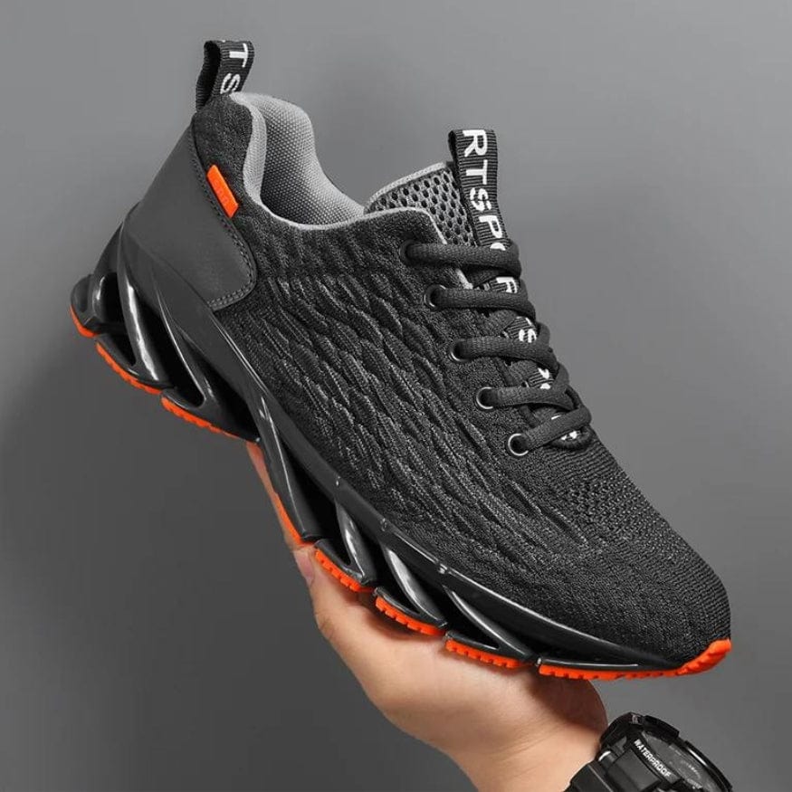 Schwarzer Sportschuh mit orangen Akzenten, atmungsaktives Mesh, rutschfeste Sohle.