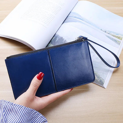 Damenhandtasche aus blauem Leder mit Reißverschluss, elegant, modisch, auf Holztisch.