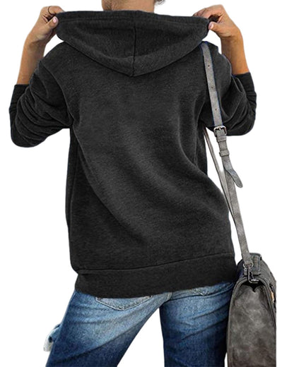Person in schwarzem Kapuzenpullover und blauer Jeans mit grauer Umhängetasche von hinten.