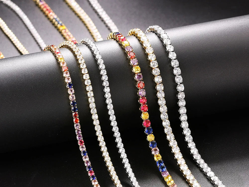 Mehrfarbige Tennisarmbänder mit Edelsteinen auf schwarzem Hintergrund, luxuriöser Schmuck.