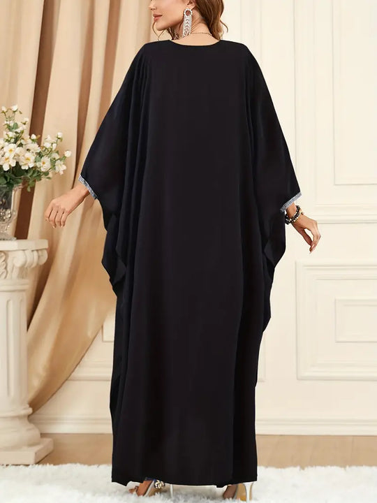 Frau in schwarzem Kaftan, elegantes Abendkleid, fließender Stoff, modische Abendmode.