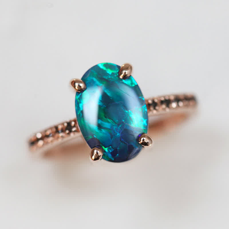Opalring mit blau-grünem Edelstein, Roségoldfassung, eleganter Schmuck, Damenring.