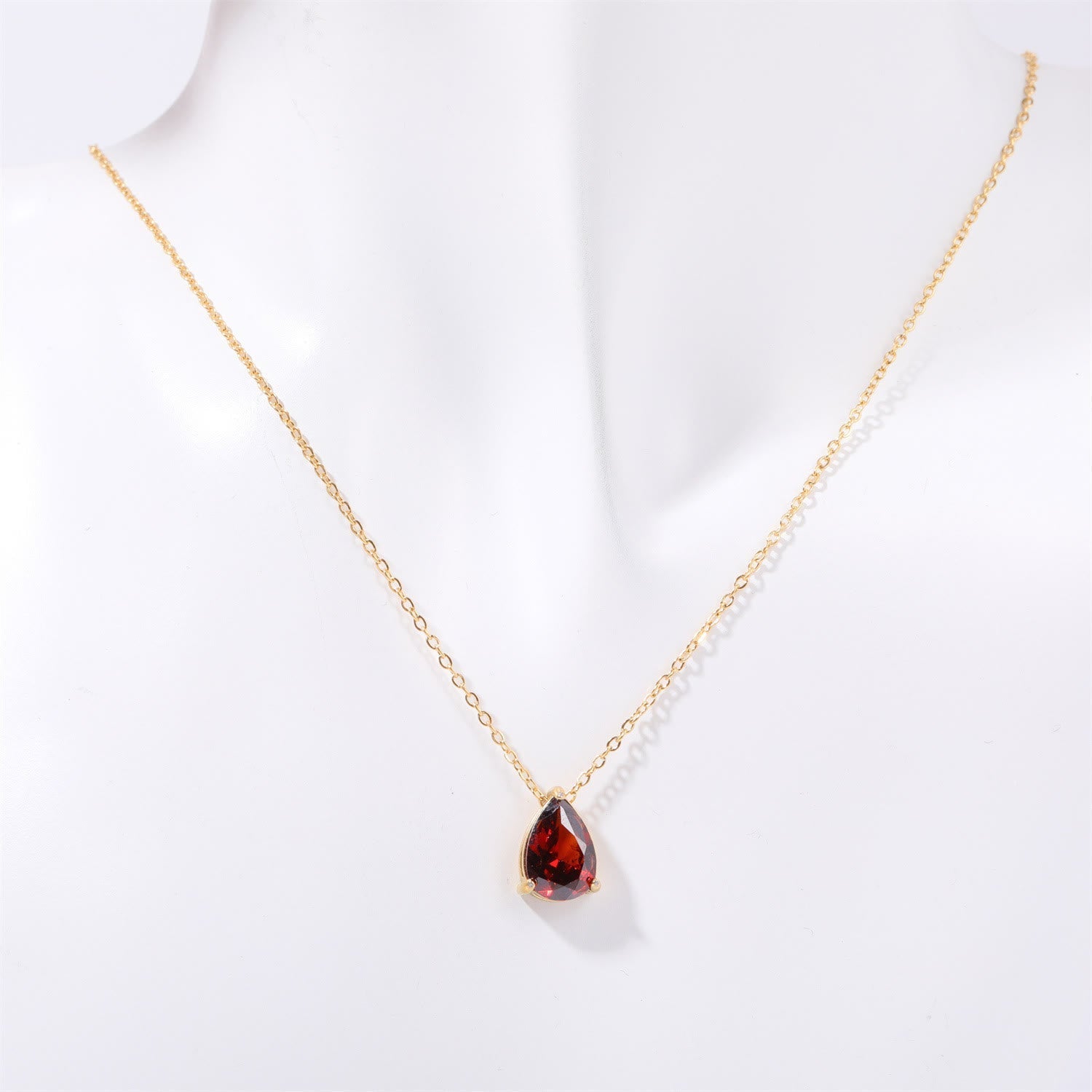 Goldene Halskette mit rotem Tropfenanhänger, eleganter Schmuck, Damenaccessoire.
