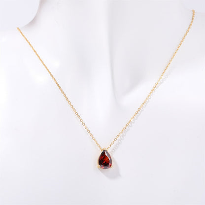 Goldene Halskette mit rotem Tropfenanhänger, eleganter Schmuck, Damenaccessoire.