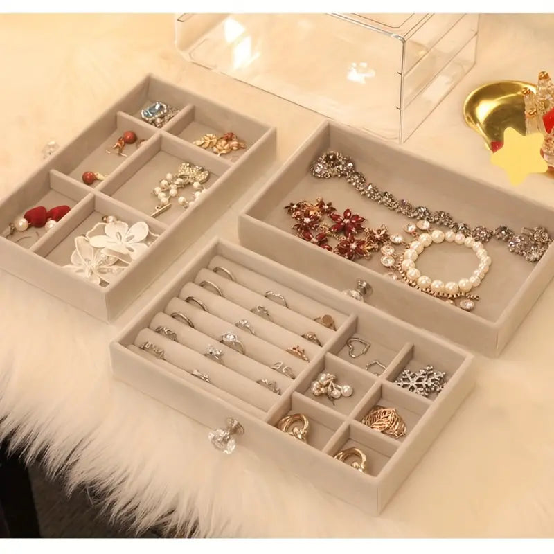 Beige Schmuck-Organizer aus Samt mit Fächern, ideal zur Aufbewahrung von Ohrringen und Armbändern.