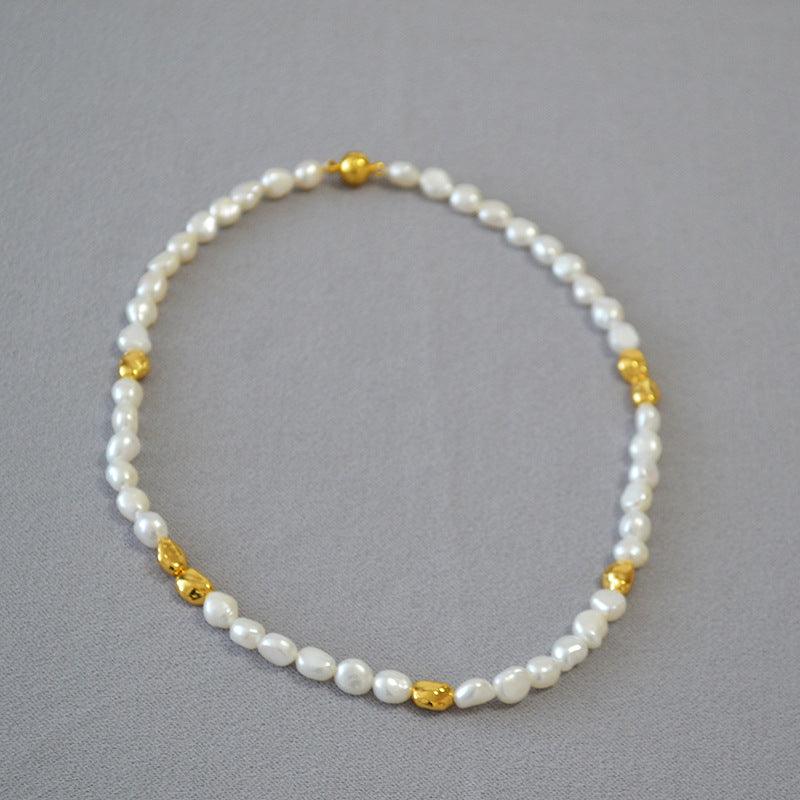 Perlenkette mit goldenen Akzenten, eleganter Schmuck, weiß, klassisches Design, Damenaccessoire.
