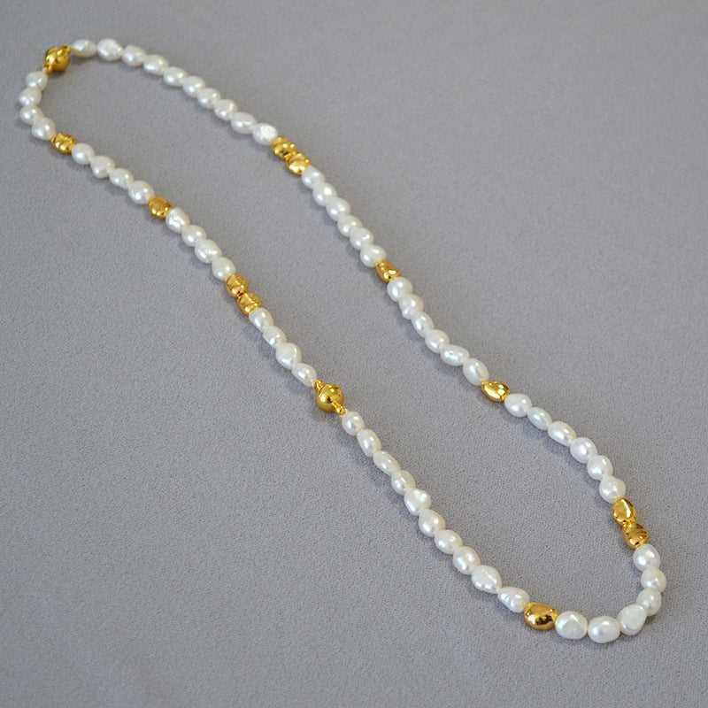Perlenkette mit goldenen Akzenten, elegant, Schmuck, Damenaccessoire, modisch, hochwertig.
