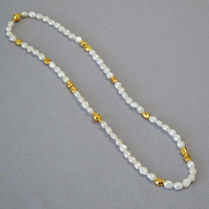 Perlenkette mit goldenen Akzenten, elegant, Schmuck, Damenaccessoire, modisch, hochwertig.