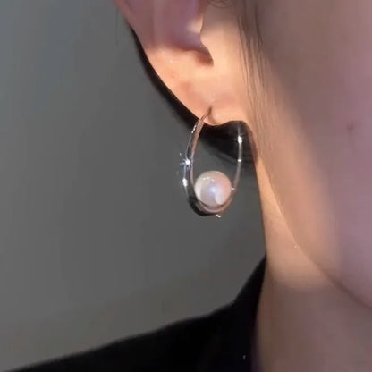 Silberner Ohrring mit Perle, eleganter Schmuck, modisches Accessoire für Damen.