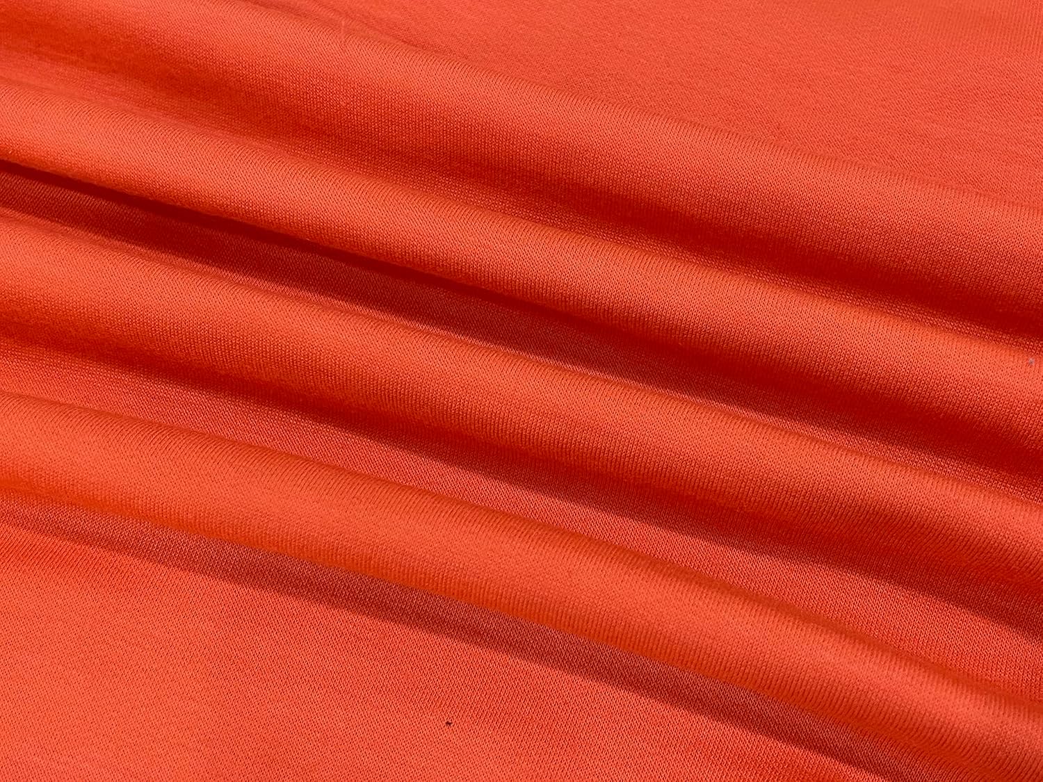 Orangefarbener Baumwollstoff, weicher Textilstoff, ideal für Kleidung und Dekoration.