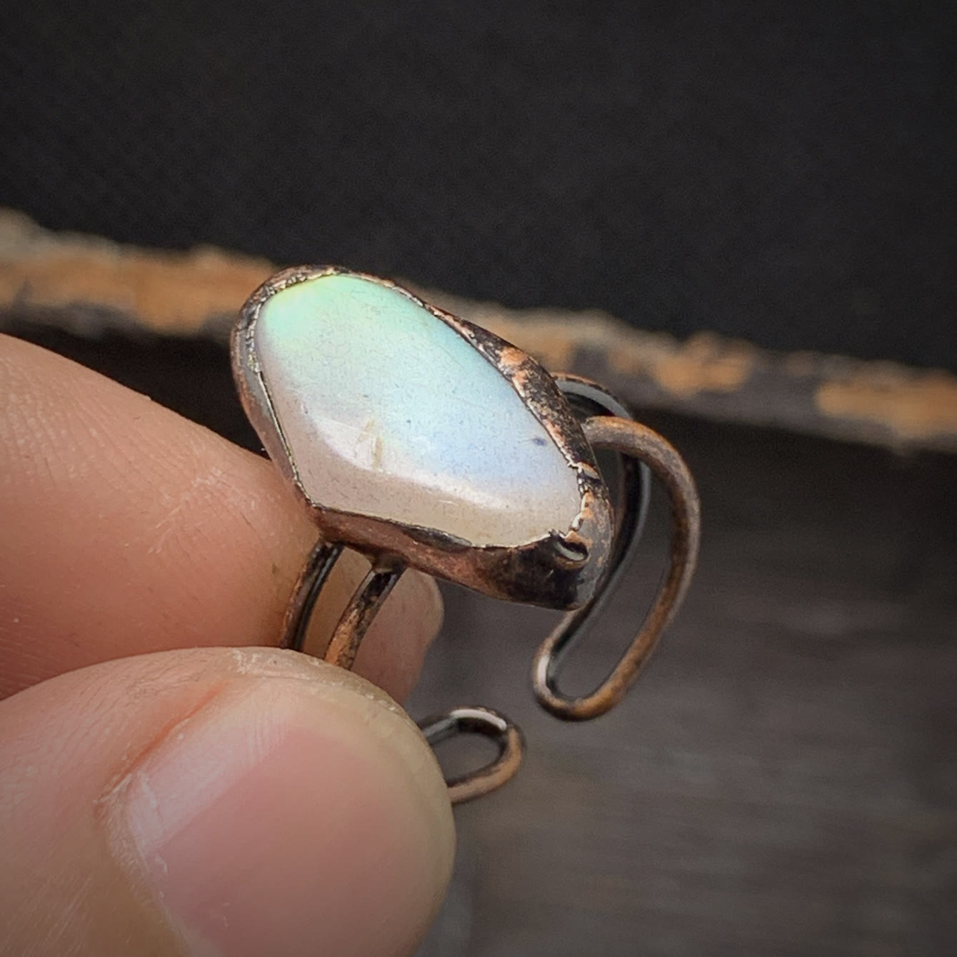 Handgefertigter Ring mit weißem Opalstein und Kupferfassung, einzigartiges Schmuckdesign.