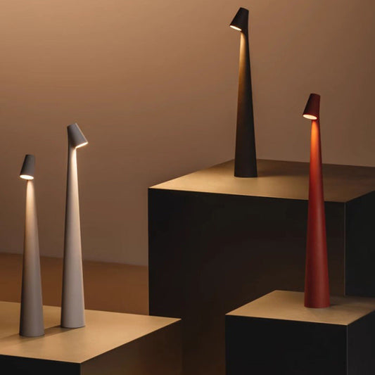 Moderne LED-Stehlampen in Schwarz, Weiß und Rot auf Podesten, minimalistisches Design.