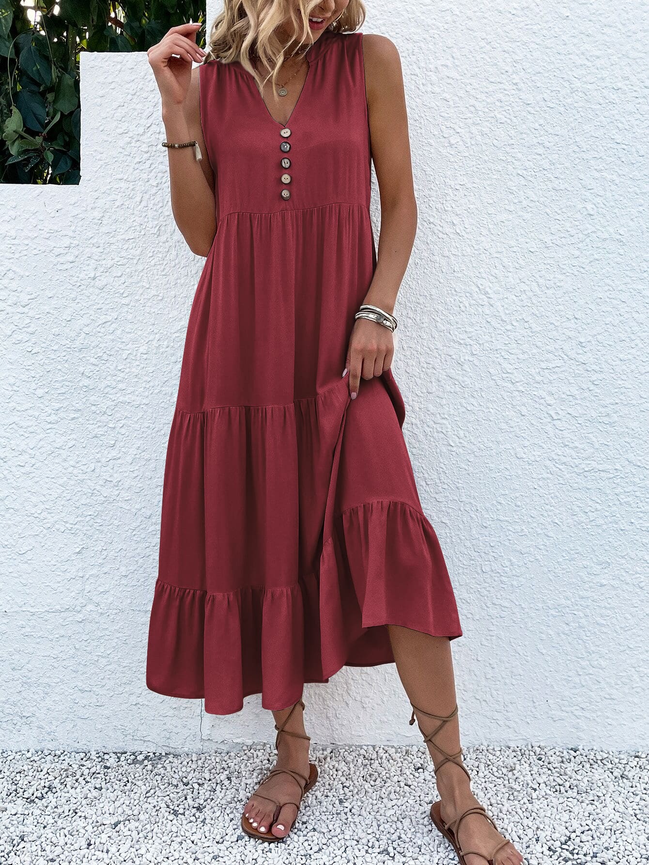 Frau in rotem Sommerkleid mit Knopfleiste, ärmellos, knielang, vor weißer Wand.