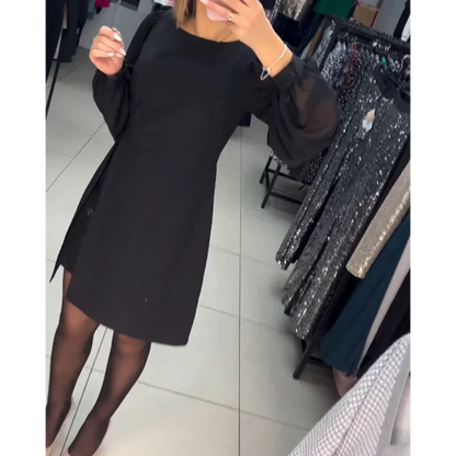Schwarzes Kleid mit langen Ärmeln, elegantes Design, Damenmode, im Bekleidungsgeschäft.