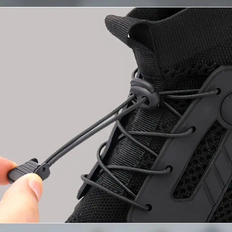 Schwarzer Sneaker mit elastischem Schnürsystem, atmungsaktivem Mesh-Obermaterial, Nahaufnahme.