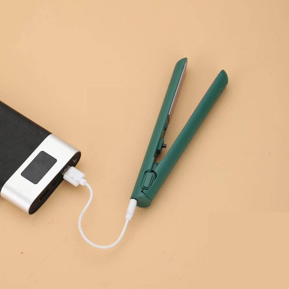 Grön plattång kopplad med vit USB-sladd till en svart och silverfärgad powerbank på beige bakgrund. 11