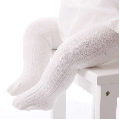 Weiße Babystrumpfhose aus Baumwolle, Zopfmuster, auf weißem Stuhl, bequem und weich.