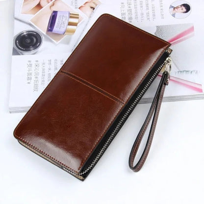 Braune Leder-Geldbörse mit Reißverschluss und Handschlaufe auf Magazin, stilvoll und elegant.