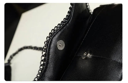 Schwarze Lederhandtasche mit Kettenriemen und Magnetverschluss, elegant und modern.