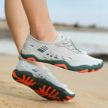 Weiße Barfußschuhe mit oranger Sohle, ideal für Strandlauf, atmungsaktiv und leicht.
