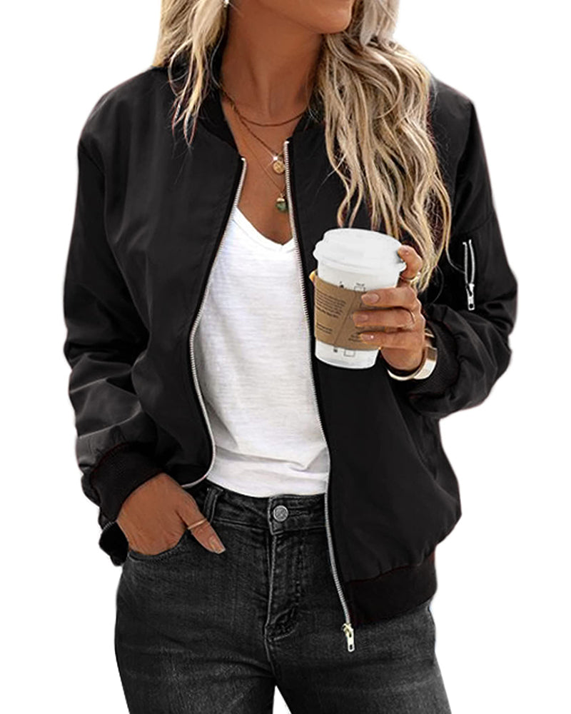 Frau in schwarzer Bomberjacke, weißem T-Shirt, hält Kaffeebecher, lässiger Streetstyle-Look.