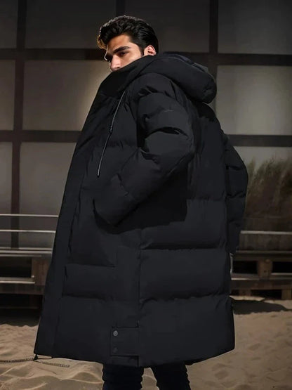 Mann in schwarzem Daunenmantel mit Kapuze, Wintermode, Outdoor-Bekleidung, stilvoller Look.